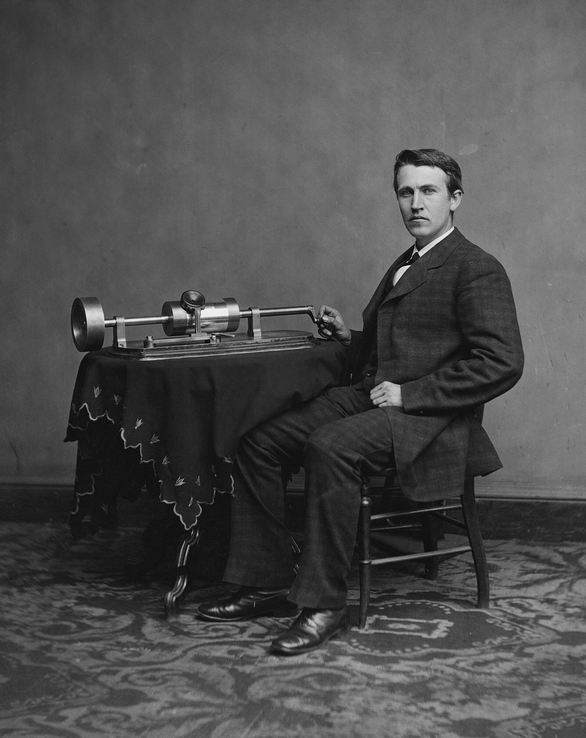 Thomas Edison seated beside an early phonograph, photographed in 1878.