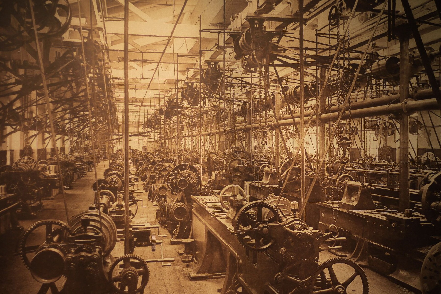 Belt-driven machinery operating inside a nineteenth-century factory.