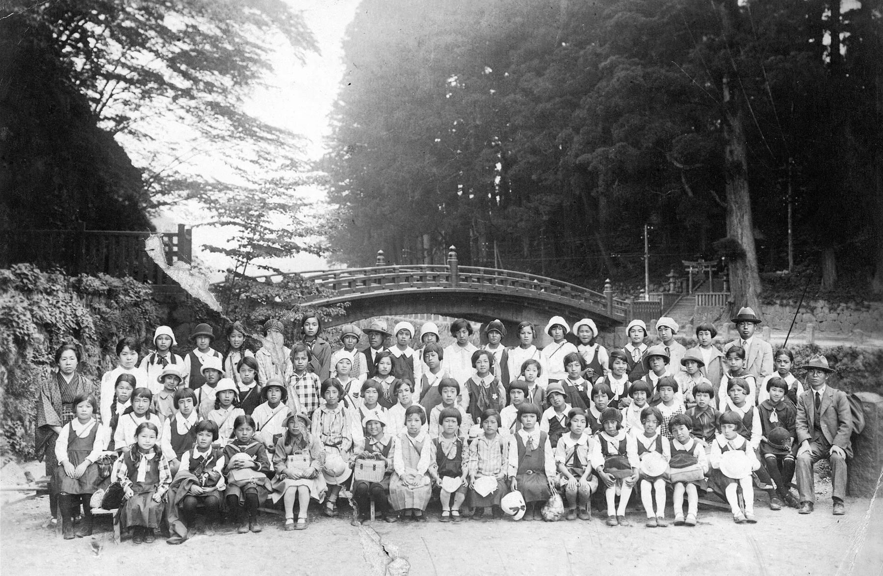 C. 1940s group photo of girls in school uniforms with teachers in Japan, an archival visual related to Why Do Schools Have Uniforms.